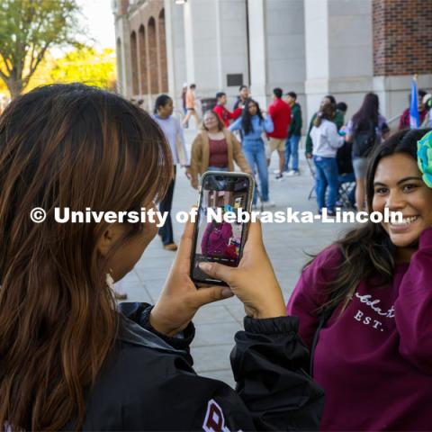 Lambda Theta Nu Sorority helped visitors make tissue paper flowers. A student models her creation. Fiesta on the green at the Nebraska Union Plaza. Fiesta on the Green is an annual Latino culture and heritage festival. October 5, 2023. Photo by Kristen Labadie / University Communication.